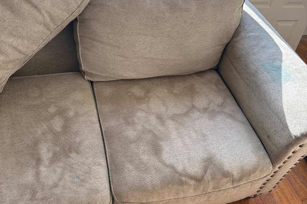 Stained fabric upholstery seats with visible dirt before professional steam cleaning