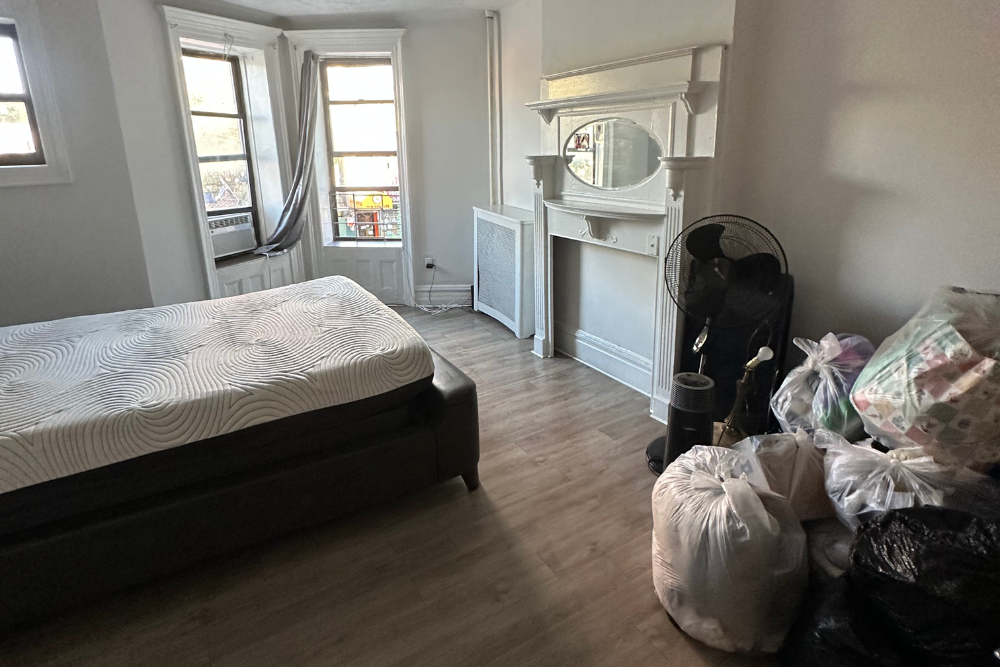 Organized bedroom with consolidated trash bags after professional anti-hoarding cleanup and decluttering service