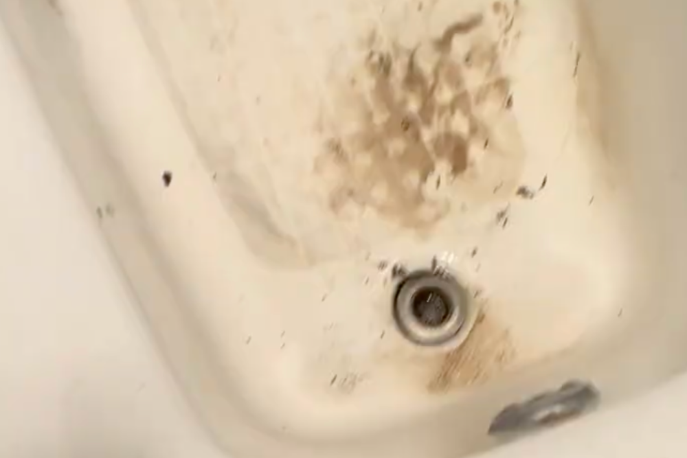 Stained dirty bathtub with soap scum and grime before professional deep cleaning