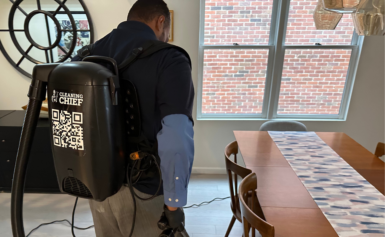 Professional cleaner performing high-end cleaning service in luxury apartment living room